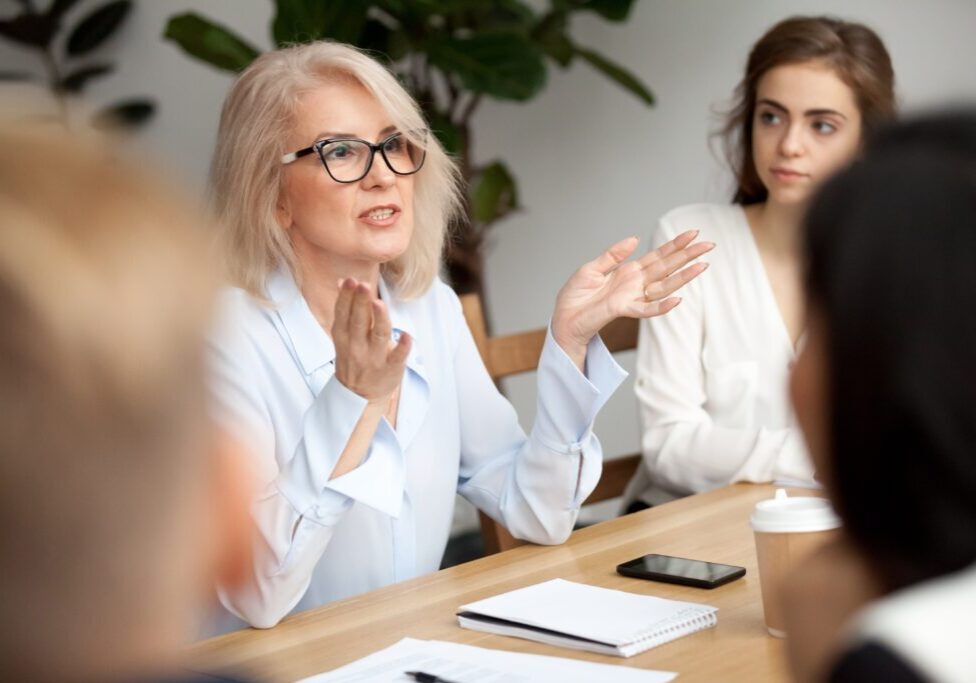 A woman sitting at a table with other people.