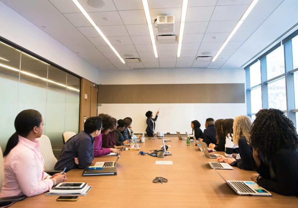 A group of people sitting at a table with laptops.